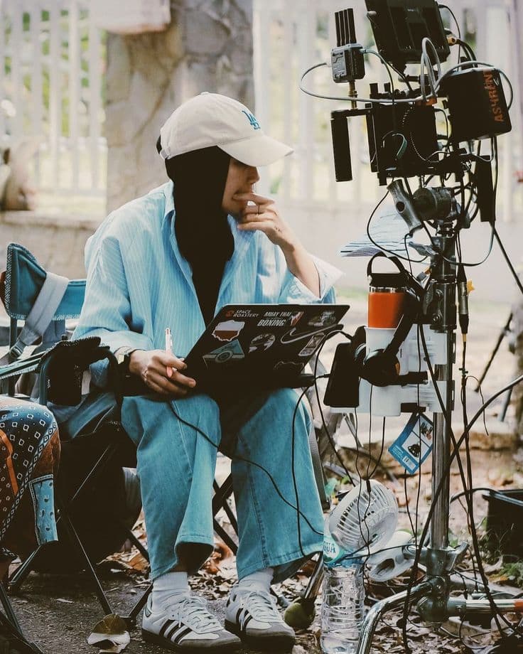 A filmmaker reviewing footage on set with her camera equipment